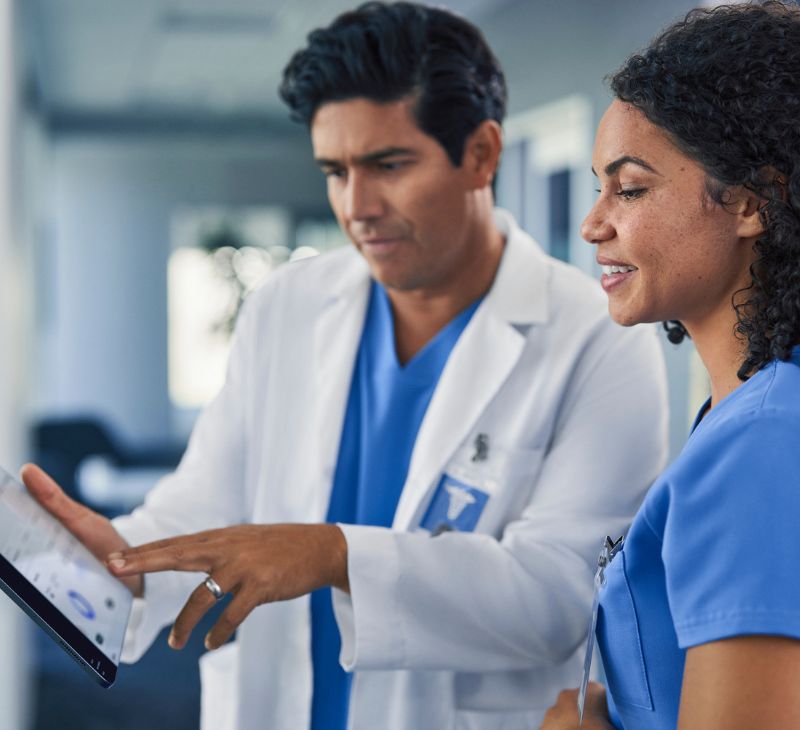 Nurses look at tablet together.