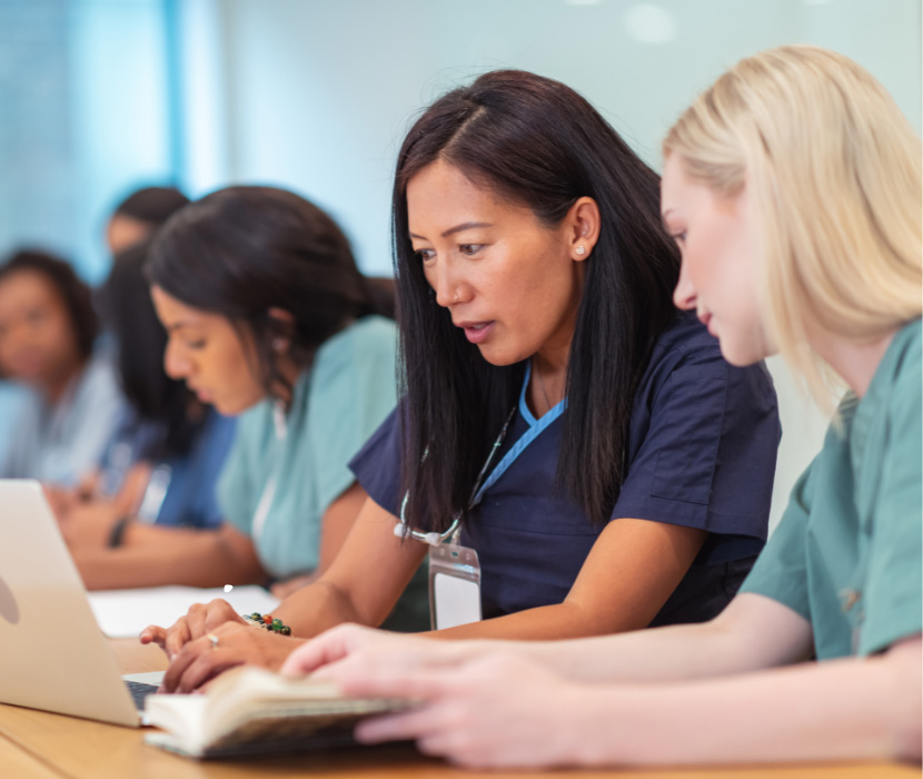 Person sits at table in house typing on a laptop.