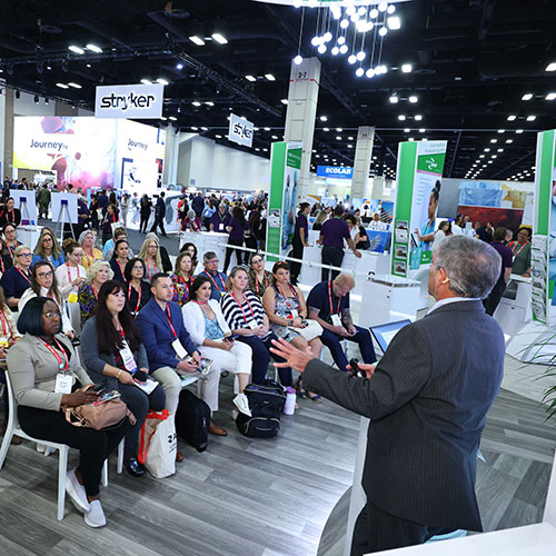 Man speaks to crowd of listeners in the Expo Hall.