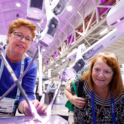 Two Periop Nurses check out robotics demo in Expo Hall.