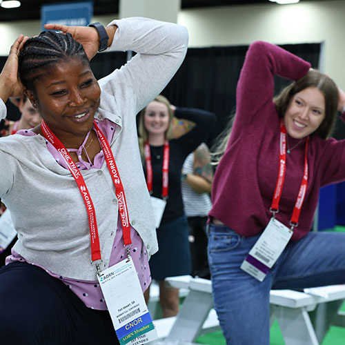 Two women do stretching exercises during Expo 2023.